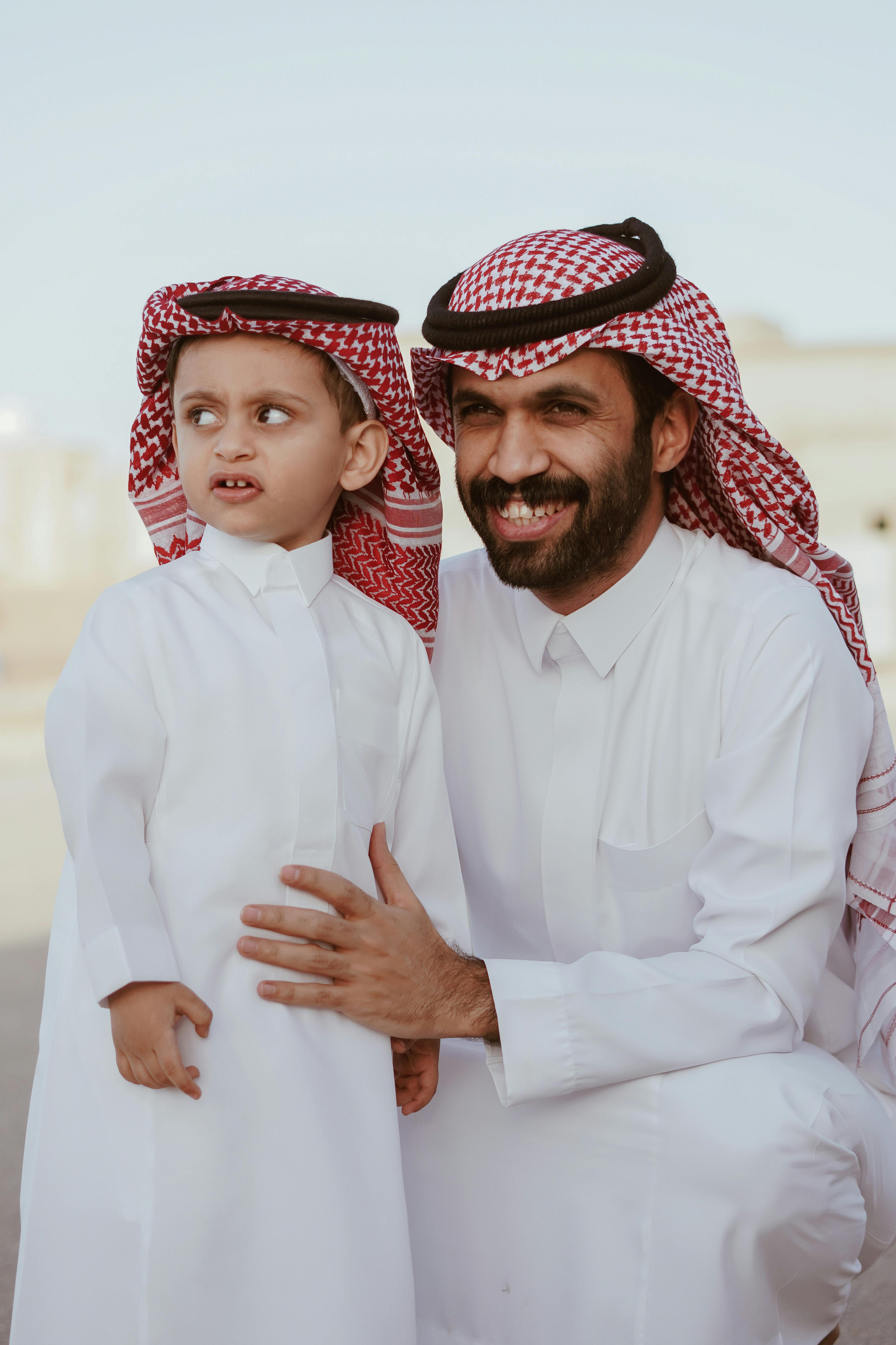 Arab father smiling warmly with his young son