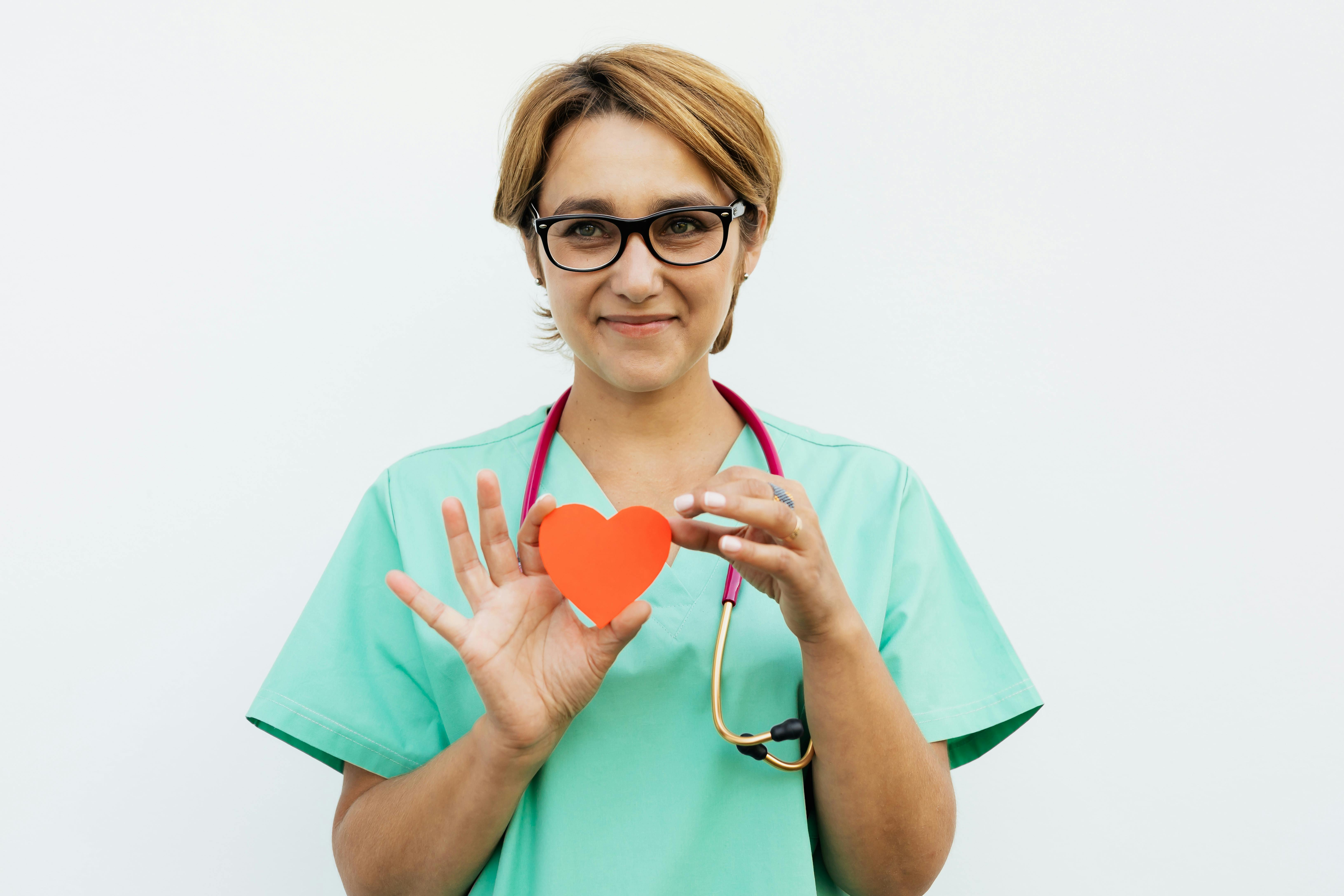 Doctor holding a red heart — caring for patients with love