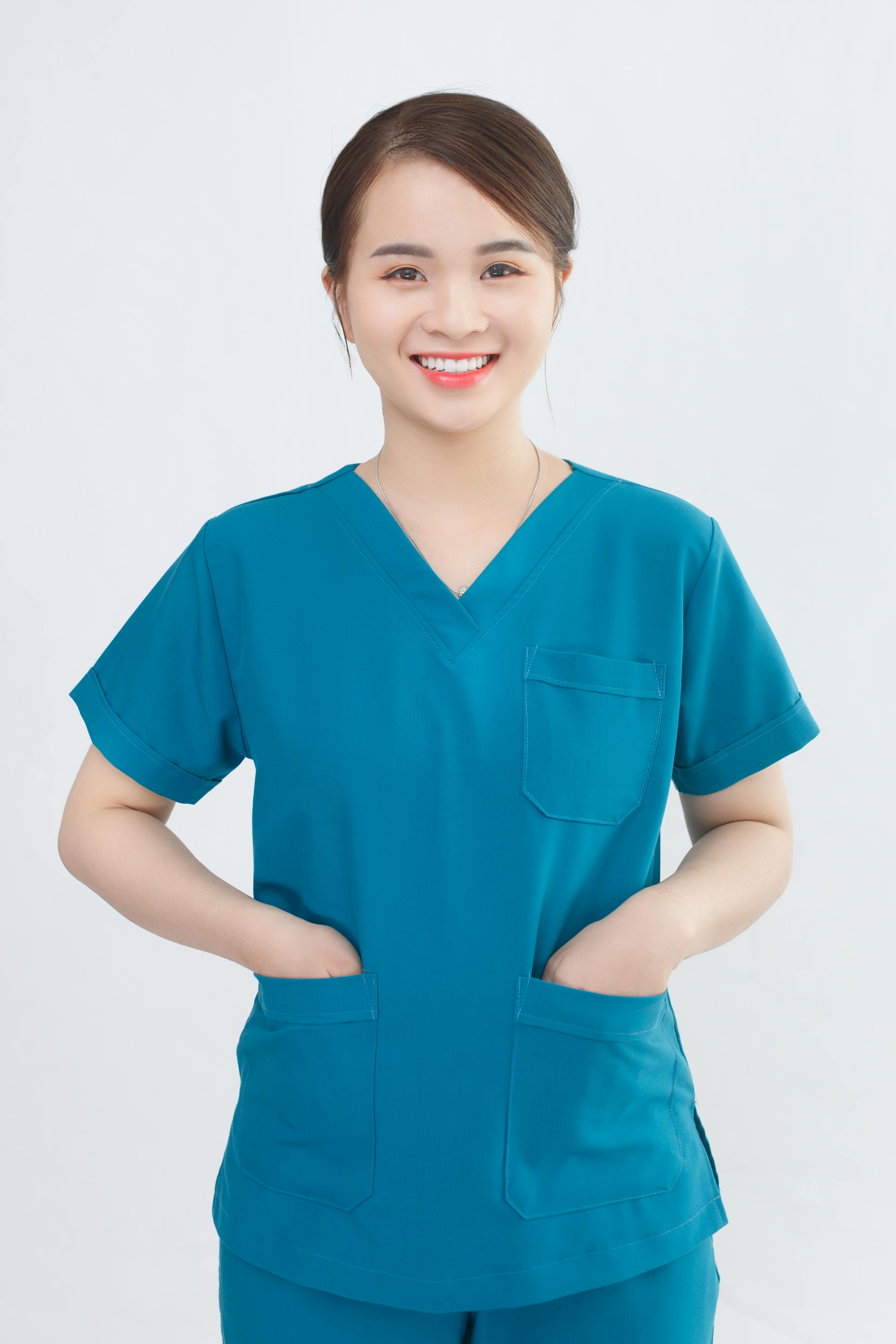 Healthcare professional in teal scrubs smiling warmly